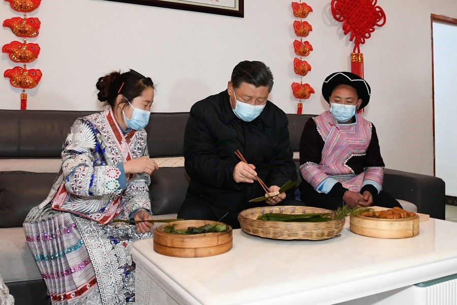 2021年2月3日下午，習(xí)近平在貴州畢節(jié)市黔西縣新仁苗族鄉(xiāng)化屋村苗族村民趙玉學(xué)家，同一家人邊聊家常邊制作當(dāng)?shù)貍鹘y(tǒng)節(jié)日食品黃粑。新華社記者 李學(xué)仁 攝
