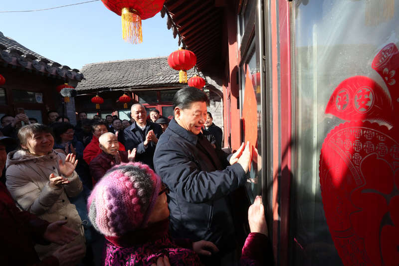 2019年2月1日上午，習(xí)近平在北京前門東區(qū)草廠四條胡同32號院，高興地拿起一幅“?！弊?，親自貼到門上，給這里的老街坊們拜年。新華社記者 鞠鵬 攝
