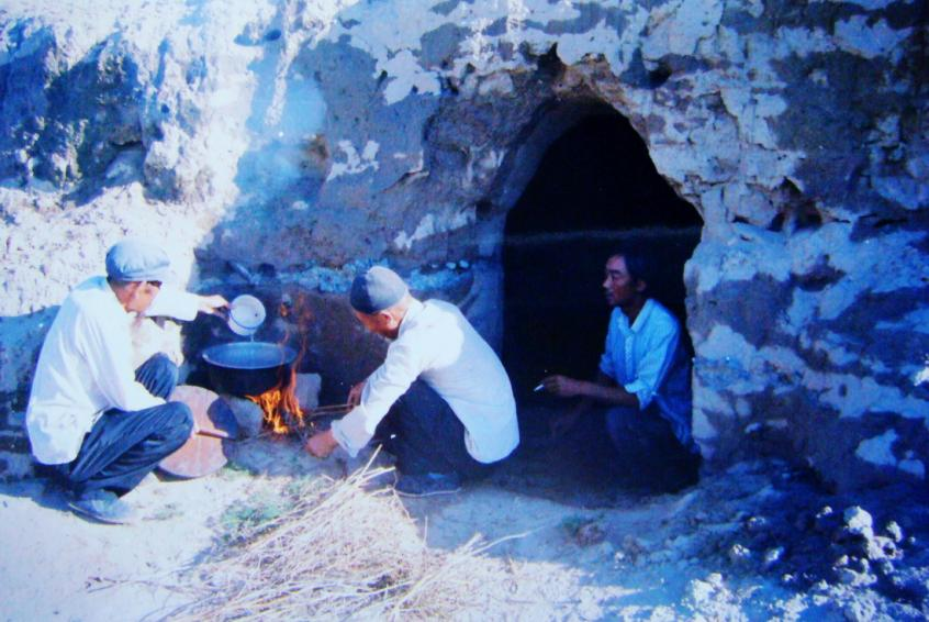 1983年，“六老漢”一代治沙人在“地窩子”生活做飯。新華社發(fā)（八步沙林場(chǎng)供圖）