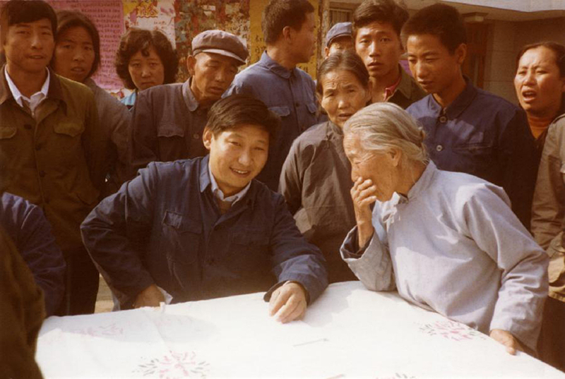 1983年，時(shí)任河北正定縣委書記的習(xí)近平（前排居中），臨時(shí)在大街上擺桌子聽取老百姓意見。